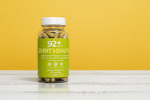 Load image into Gallery viewer, 92+ Joint Health supplement bottle with turmeric capsules on yellow background