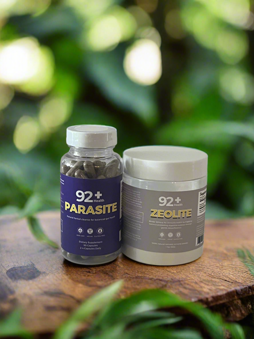 92+ Parasite Cleanse and Zeolite bottles on a wooden surface with a green blurred background.